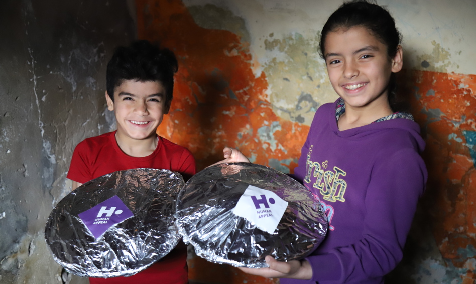 Two children holding plates with hot meals