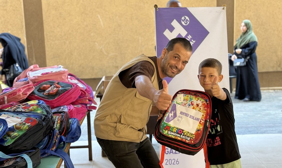 Our staff handing over a Back to School kit to a child in Gaza