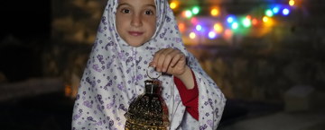 Child holding a lamp in Syria