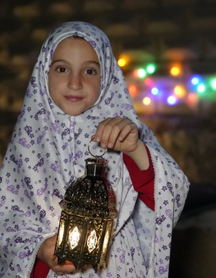 Child holding a lamp in Syria