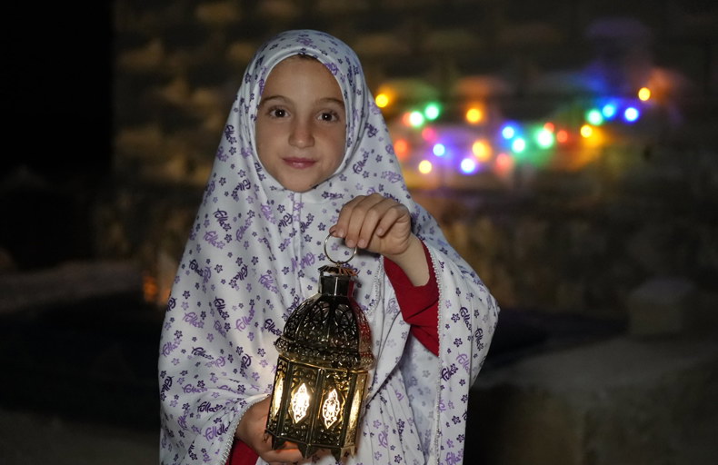 Young child in Syria holding a lantern
