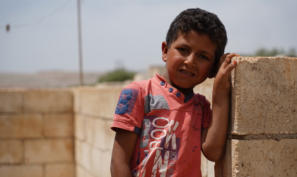 Child leaning against a wall