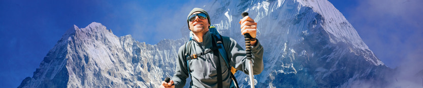 Man in winter hiking gear, with Everest in the background