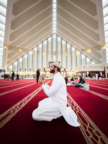 Man praying in Faisal mosque, Pakistan