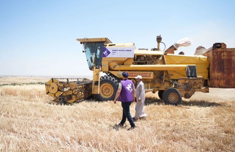 Human Appeal staff member next to mechanical farm equipment