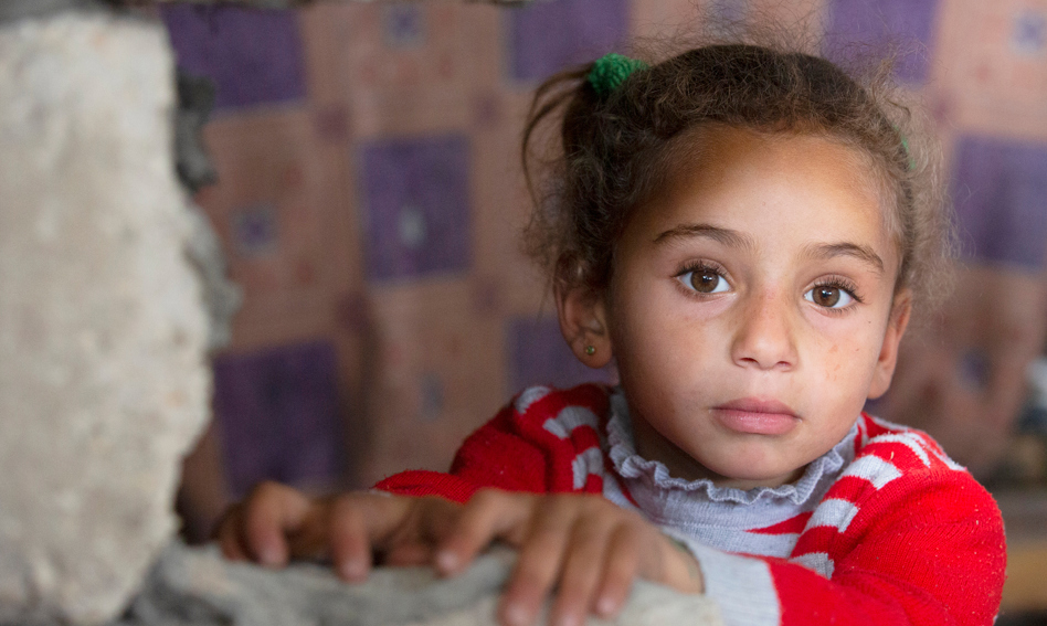 Girl looking over a wall in Gaza