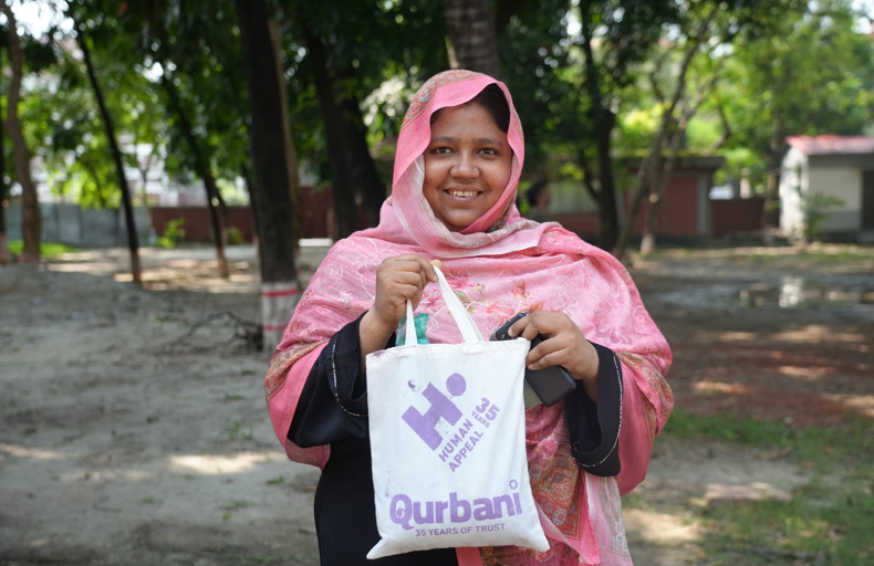 Woman holding up Qurbani parcel