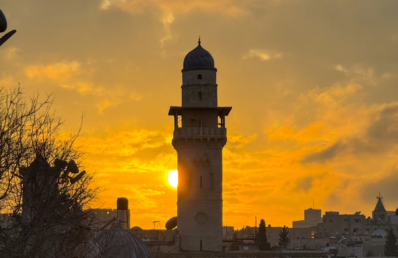 Minaret silhouetted against sunlight