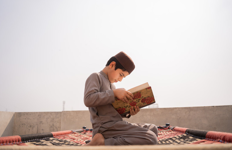 Child reading a book, learning about what is haram and halal