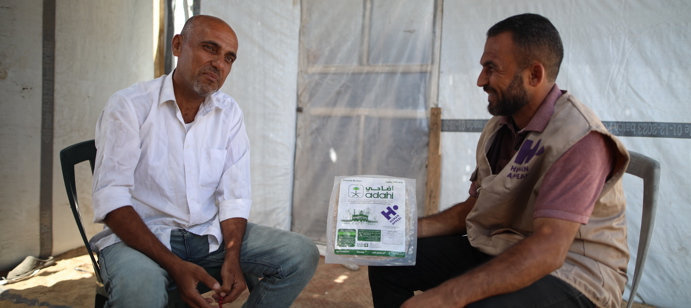 A member of our staff chatting with a recipient of Qurbani. 