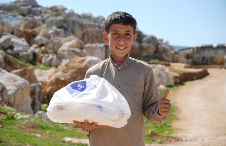 Young boy holding up a fidya parcel