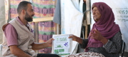 An older woman receiving a Qurbani package. 