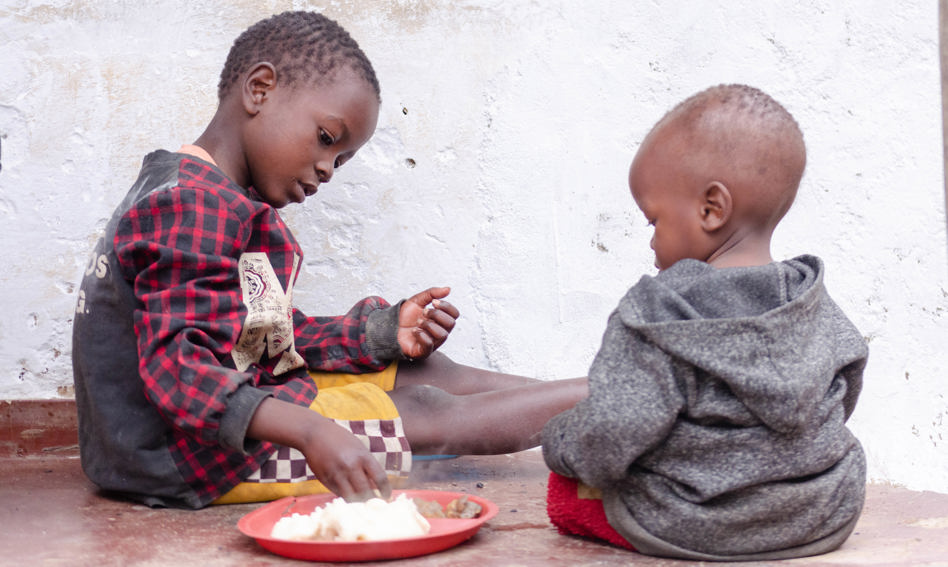Pair of children eating from plate