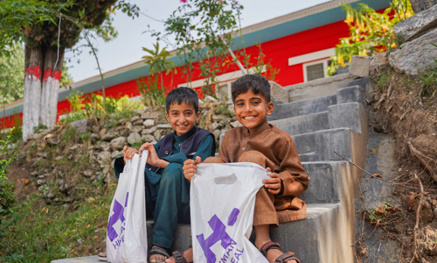 Children holding their Qurbani meat parcels