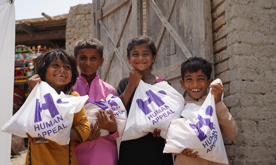 Children in Pakistan holding their Qurbani meat