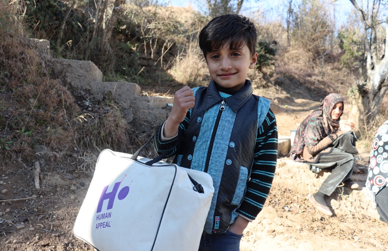 Young Pakistani boy holding his winter kit