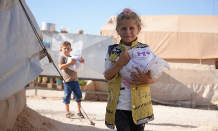 Child holding Qurbani parcel