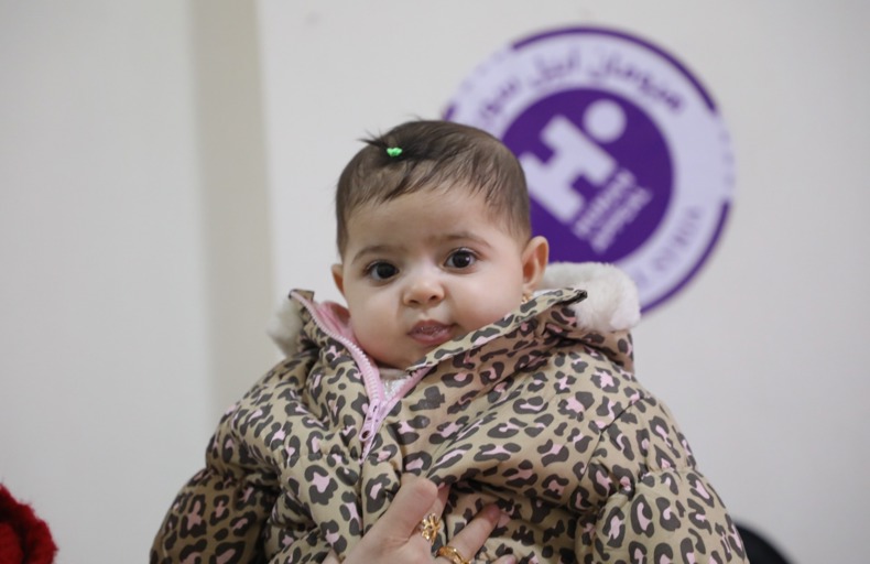 Baby's hand being held between the hands of another person