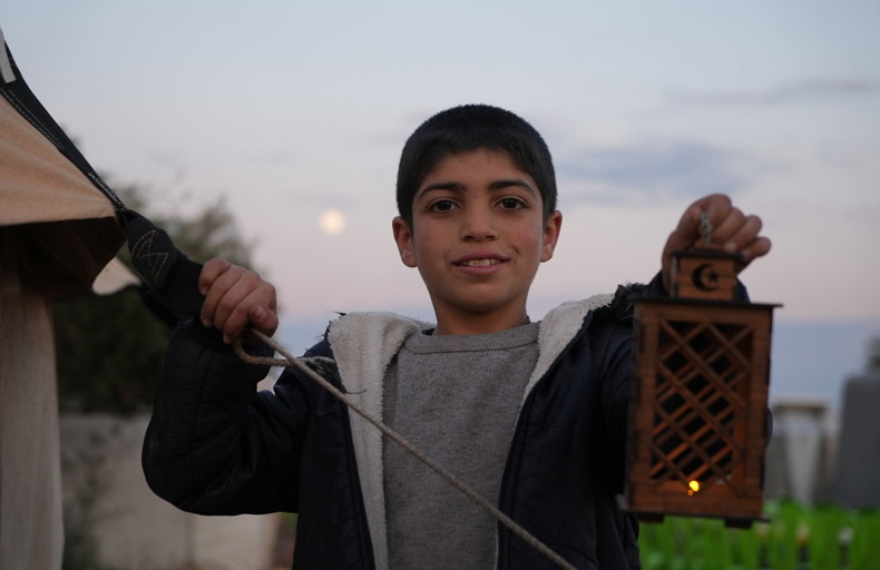 Child holding a lamp in Syria