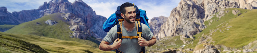 Man with backpack, with mountains in the background