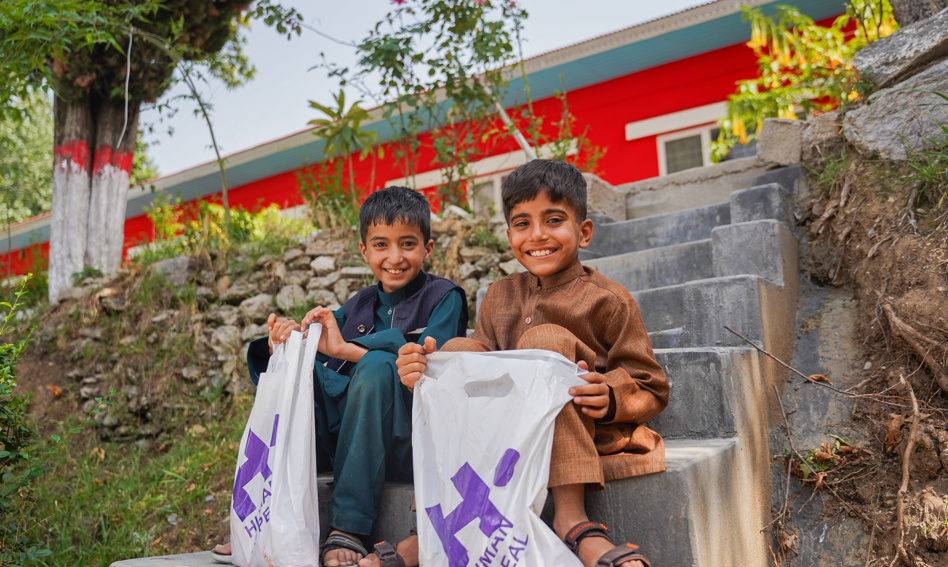 Two boys with Qurbani bags