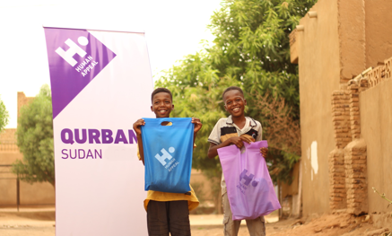 Two boys with Qurbani bags